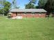 Expansive backyard featuring lush green lawn, patio and brick home, perfect for outdoor activities at 1700 Warrenton Rd, Henderson, NC 27537