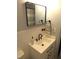 Close-up showcasing bathroom sink with modern faucet, white vanity, and stylish mirror and wall decor at 1700 Warrenton Rd, Henderson, NC 27537
