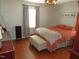 Cozy bedroom with hardwood floors, a decorative light fixture, and a large bed topped with stylish bedding at 1700 Warrenton Rd, Henderson, NC 27537