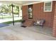 Covered carport area with brick steps, black handrails and bench seating by the front door at 1700 Warrenton Rd, Henderson, NC 27537