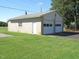 Two-car garage with concrete block walls, updated with a white gable and a chimney, offers parking, storage, and workspace at 1700 Warrenton Rd, Henderson, NC 27537