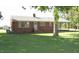 Charming single-story brick home with well-maintained lawn and a detached garage under the shade of mature trees at 1700 Warrenton Rd, Henderson, NC 27537