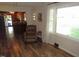 Comfortable living room featuring hardwood floors, a large window, and an inviting chair at 1700 Warrenton Rd, Henderson, NC 27537