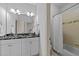 Bathroom featuring double vanity, granite countertop, and a shower with tiled surround at 1711 Happiness Hill Ln, Raleigh, NC 27614