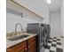 Well-equipped laundry room with granite countertop, stainless steel sink and modern washer and dryer at 1711 Happiness Hill Ln, Raleigh, NC 27614
