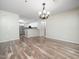 Open dining area offering hardwood flooring, an elegant chandelier, and a view of the kitchen at 1911 Falls Landing Dr # 106, Raleigh, NC 27614