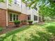 Charming exterior showcasing brick accents and a screened porch, surrounded by lush greenery at 1911 Falls Landing Dr # 106, Raleigh, NC 27614