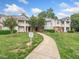 Inviting exterior view of condo building featuring lush lawn and manicured landscaping at 1911 Falls Landing Dr # 106, Raleigh, NC 27614