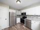 Well-equipped kitchen with stainless steel appliances, white cabinets, and modern backsplash at 1911 Falls Landing Dr # 106, Raleigh, NC 27614