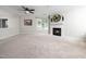 Spacious living room featuring neutral tones, large window, fireplace, and modern ceiling fan at 1911 Falls Landing Dr # 106, Raleigh, NC 27614