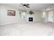 Neutral toned living room with ceiling fan, fireplace, and large window at 1911 Falls Landing Dr # 106, Raleigh, NC 27614