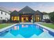 A backyard view of the home highlighting a large swimming pool, covered patio, and manicured lawn at 2120 Kipawa St, Raleigh, NC 27607