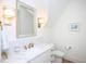 Well-lit powder room with a marble countertop, modern fixtures, and a decorative mirror at 2120 Kipawa St, Raleigh, NC 27607