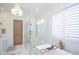 Bathroom features marble walls, glass shower, soaking tub, shuttered windows, and a chandelier at 2120 Kipawa St, Raleigh, NC 27607