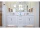 Bathroom with double sink vanity, stone counter tops, and chandelier lighting with decorative mirrors at 2120 Kipawa St, Raleigh, NC 27607
