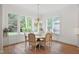 Bright dining room features a chandelier, hardwood floors, and many windows overlooking the garden at 2120 Kipawa St, Raleigh, NC 27607