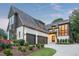 Beautiful two-story home featuring a manicured lawn, three-car garage, and brick and wood exterior at 2120 Kipawa St, Raleigh, NC 27607