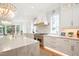 Bright kitchen with a large island, modern appliances, white cabinets, and open dining area at 2120 Kipawa St, Raleigh, NC 27607
