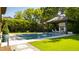 Backyard with a sparkling pool, cabana with a fireplace and outdoor seating at 2120 Kipawa St, Raleigh, NC 27607