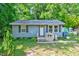 Charming single-story home with blue siding and a quaint front porch, surrounded by lush greenery at 230 Parkland Rd, Raleigh, NC 27603