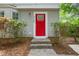 Close-up of a vibrant red front door with decorative glass, complemented by stone steps and lush greenery at 2309 Hoot Owl Ct, Raleigh, NC 27603