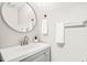 Stylish half bath with modern vanity, fixtures, and round mirror at 2309 Hoot Owl Ct, Raleigh, NC 27603