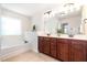 Bright bathroom featuring a soaking tub and a vanity with granite countertops at 233 Hammond Wood Place, Morrisville, NC 27560