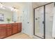 Bright bathroom featuring a double vanity, wood cabinets and a glass enclosed shower at 233 Hammond Wood Place, Morrisville, NC 27560