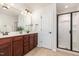 Bright bathroom featuring a double vanity, granite countertops, and a modern glass shower at 233 Hammond Wood Place, Morrisville, NC 27560