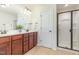 Bright bathroom featuring a double vanity, wood cabinets and a glass enclosed shower at 233 Hammond Wood Place, Morrisville, NC 27560