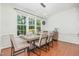 Well-lit dining room with modern light fixture, large windows, and wood floors at 233 Hammond Wood Place, Morrisville, NC 27560