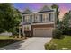 Charming two-story home featuring gray siding, brick accents, a two-car garage, and a well-maintained front yard at 233 Hammond Wood Place, Morrisville, NC 27560