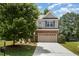Charming two-story home featuring gray siding, brick accents, a two-car garage, and a well-maintained front yard at 233 Hammond Wood Place, Morrisville, NC 27560