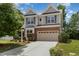 Charming two-story home featuring gray siding, brick accents, a two-car garage, and a well-maintained front yard at 233 Hammond Wood Place, Morrisville, NC 27560