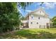 Spacious backyard showcasing a well-maintained lawn, mature trees, and a cozy patio with a pergola at 233 Hammond Wood Place, Morrisville, NC 27560