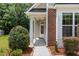 Inviting front porch with classic columns and brick accents, providing a warm welcome to the home at 233 Hammond Wood Place, Morrisville, NC 27560