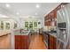 Charming kitchen featuring dark wood cabinets, granite countertops, stainless appliances, and an eat-in area at 233 Hammond Wood Place, Morrisville, NC 27560