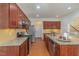 A spacious kitchen boasts granite countertops, stainless steel appliances, and wood cabinets at 233 Hammond Wood Place, Morrisville, NC 27560