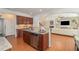 Charming kitchen featuring granite countertops, stainless steel dishwasher, and wood flooring at 233 Hammond Wood Place, Morrisville, NC 27560