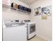 Bright laundry room with modern washer and dryer, complemented by artistic decor and functional shelving at 233 Hammond Wood Place, Morrisville, NC 27560