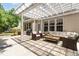 Inviting outdoor patio featuring a pergola, brick flooring, and comfortable wicker furniture for relaxing and entertaining at 233 Hammond Wood Place, Morrisville, NC 27560