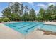 A rectangular community swimming pool with marked lanes, surrounded by lounge chairs at 233 Hammond Wood Place, Morrisville, NC 27560