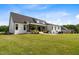 Expansive backyard featuring a well-maintained lawn and an inviting covered patio, perfect for outdoor enjoyment at 2408 Eddie Howard Rd, Willow Springs, NC 27592