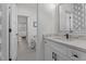 Elegant bathroom featuring modern vanity, large mirror and doorway view into the bedroom at 2408 Eddie Howard Rd, Willow Springs, NC 27592