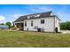 Side view of white home with black roof and trim, situated on well-maintained lawn at 2408 Eddie Howard Rd, Willow Springs, NC 27592