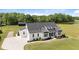 Aerial view of a modern farmhouse with manicured landscaping and a long driveway at 2408 Eddie Howard Rd, Willow Springs, NC 27592