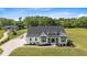 Stunning aerial view of a modern farmhouse featuring a black roof and lush green lawn at 2408 Eddie Howard Rd, Willow Springs, NC 27592