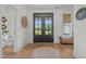 Elegant foyer with black double doors, wood floors, and natural light at 2408 Eddie Howard Rd, Willow Springs, NC 27592