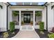 Inviting front porch with hanging ferns, seating, and a welcoming entrance at 2408 Eddie Howard Rd, Willow Springs, NC 27592
