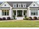 Charming front porch with black double doors, columns, and neatly manicured landscaping at 2408 Eddie Howard Rd, Willow Springs, NC 27592